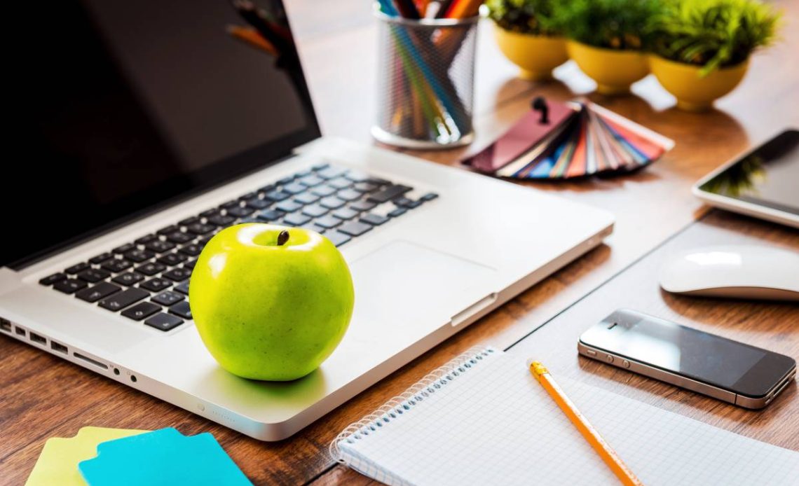 Snack for business productivity. Close-up ofcomfortable working place in office with wooden table and laptop laying on it