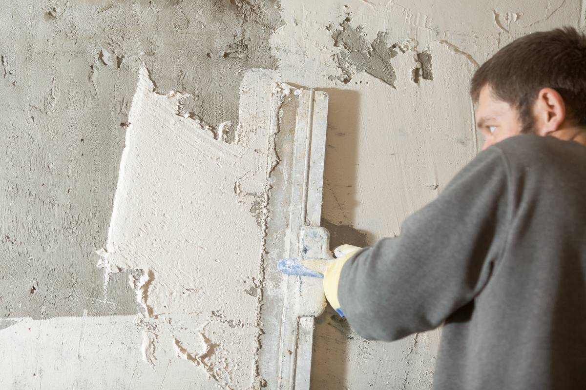 the process of smearing plaster mortar putty with a spatula on the wall close-up