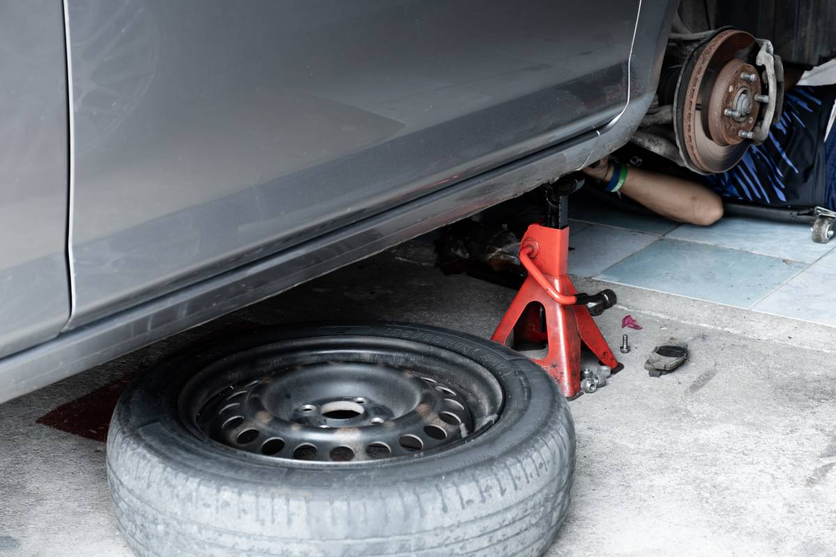 The car was lifted for change old brake car disc rotor, service new part vehicle and maintenance at the garage.