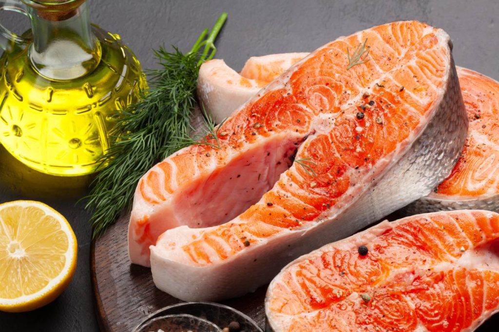 Fresh raw salmon cooking. Fish steaks with herbs and spices on cutting board